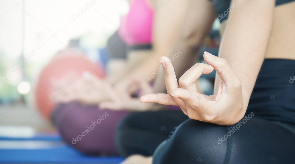 women in sportswear with hands yoga gesture on bright background