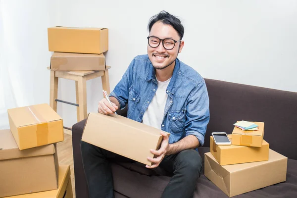 Freelance Asiático Homem Sentado Sofá Escrevendo Endereço Caixas Home Office — Fotografia de Stock