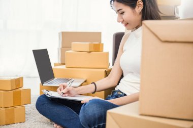 Kağıt üzerinde kutuları ve evde bilgisayar ile office yazma katta çalışan serbest kadın