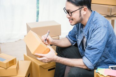 office yazma adres kutularındaki evde kanepede oturan serbest Asya adam