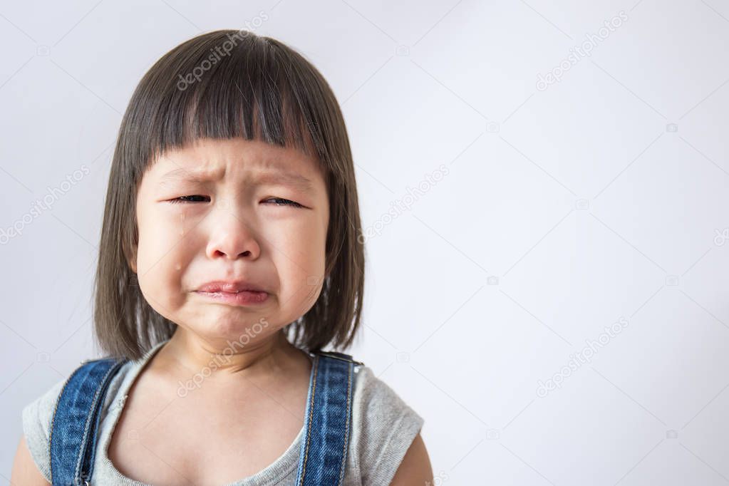 Portrait of little asian crying girl with little rolling tears 