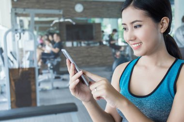 spor salonunda smartphone kullanarak güzel Asyalı kadın