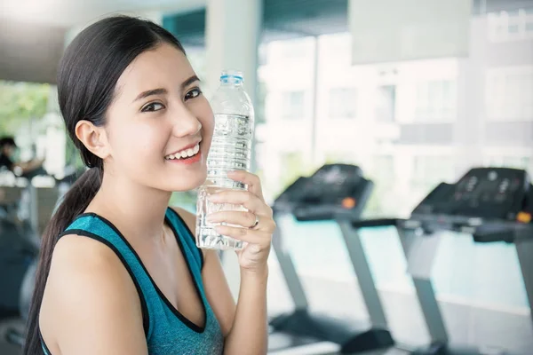 体育锻炼后的亚洲年轻女子在运动中捧瓶水 — 图库照片