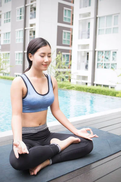 yoga hamle ve meditasyon Havuzu yakınındaki gözlü genç Asyalı kadın kapalı
