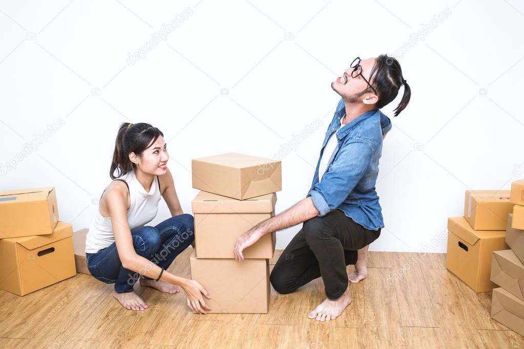 Asian woman and man in denim clothes working with boxes on floor