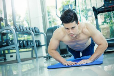 Genç Asyalı adam çalışma dışarı itme fitness merkezinde yapıyor