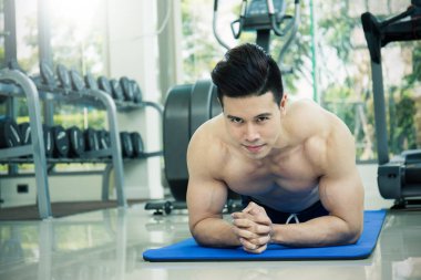 Genç Asyalı adam çalışma dışarı itme fitness merkezinde yapıyor