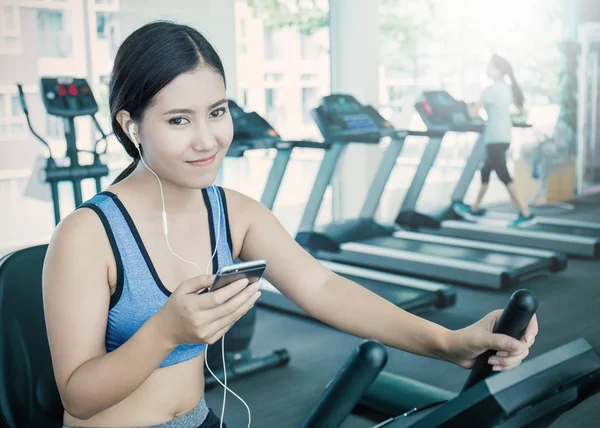 Όμορφη Γυναίκα Της Ασίας Ακούγοντας Μουσική Από Smartphone Στο Γυμναστήριο — Φωτογραφία Αρχείου