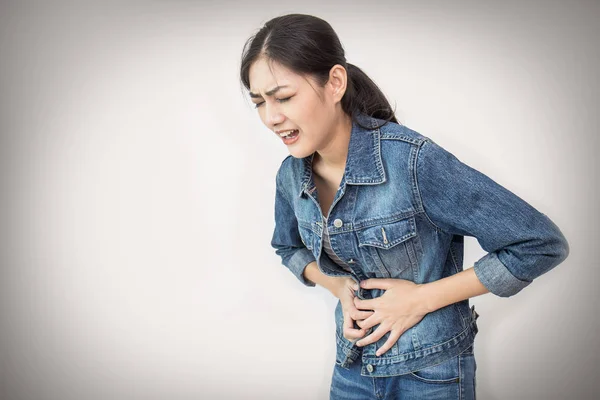 Beyaz arka plan üzerinde izole mide ağrısı olan Genç Asyalı kadın