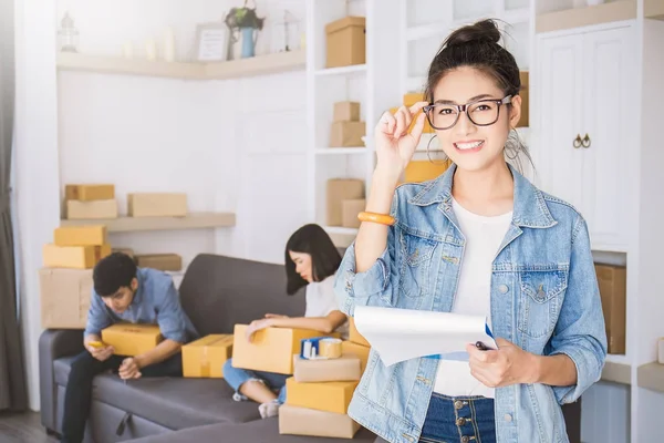 背景のソファーに座っていた人とオフィス ボックス自宅で働くフリーランスの女性 — ストック写真