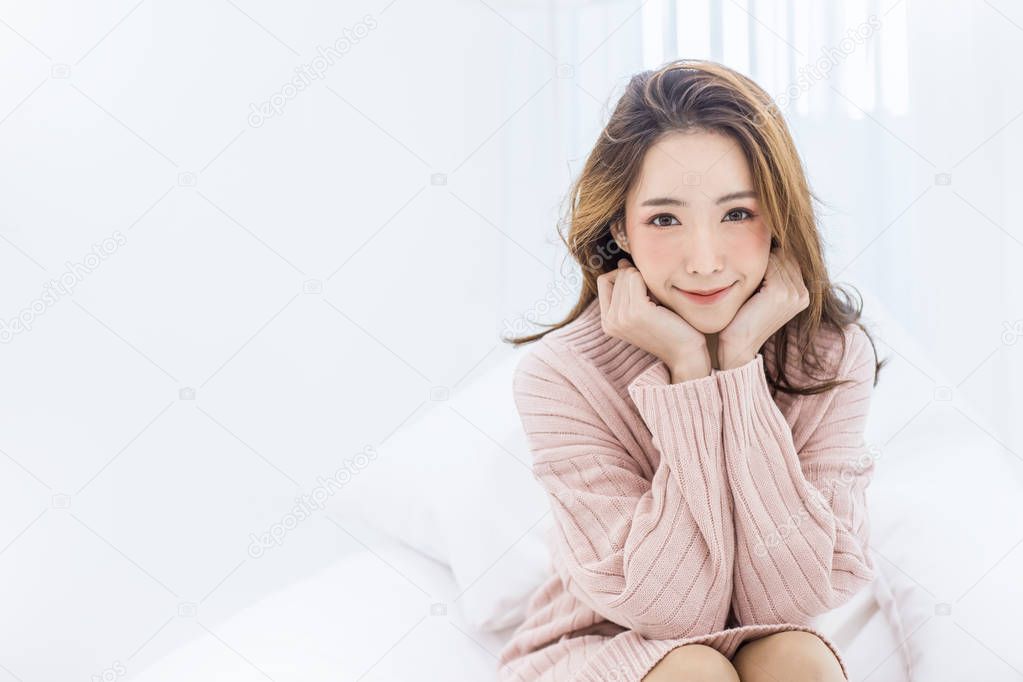 young beautiful asian woman relaxing in bedroom isolated on white background