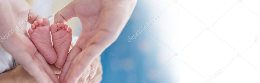 Mother and fathers hands holding newborn baby feet. Closeup hands of asian parents holding their baby feet over white bed. Healthcare love lifestyle happy caucsian family father day together concept