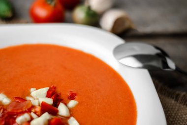 Gazpacho domates çorbası ahşap panoları ve arka plan üzerinde beyaz bir kase