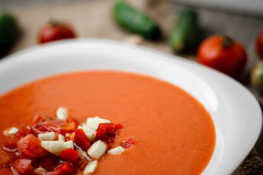 Gazpacho domates çorbası ahşap panoları ve arka plan üzerinde beyaz bir kase