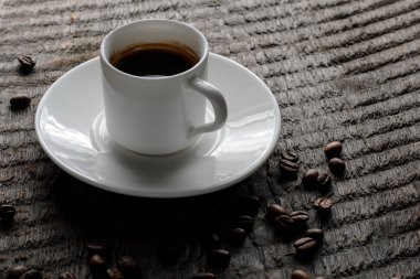 Top kahve fincanı ve kahve çekirdekleri ahşap masa arka plan üzerinde görünümü