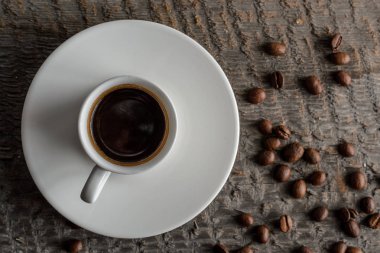 Top kahve fincanı ve kahve çekirdekleri ahşap masa arka plan üzerinde görünümü