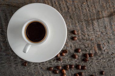 Top kahve fincanı ve kahve çekirdekleri ahşap masa arka plan üzerinde görünümü