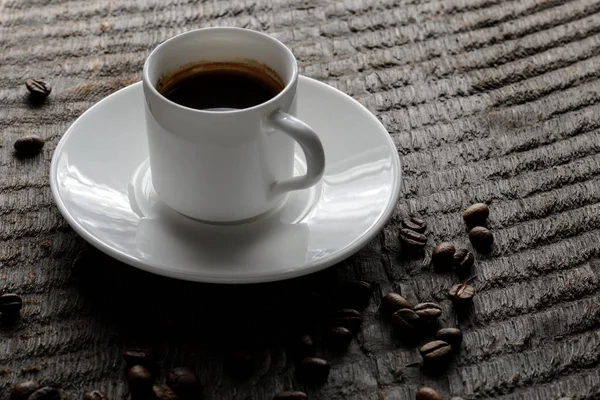 Top kahve fincanı ve kahve çekirdekleri ahşap masa arka plan üzerinde görünümü