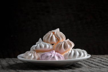 Siyah arka plan üzerine bir tabak içinde çok renkli beze