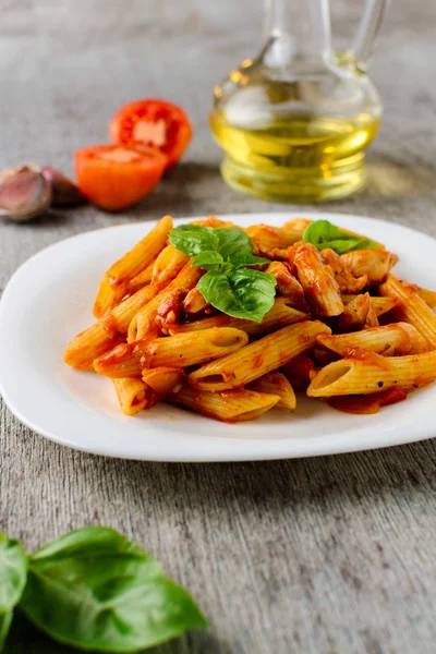 domates sosu ve fesleğen ahşap arka plan ile makarna