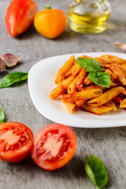 domates sosu ve fesleğen ahşap arka plan ile makarna