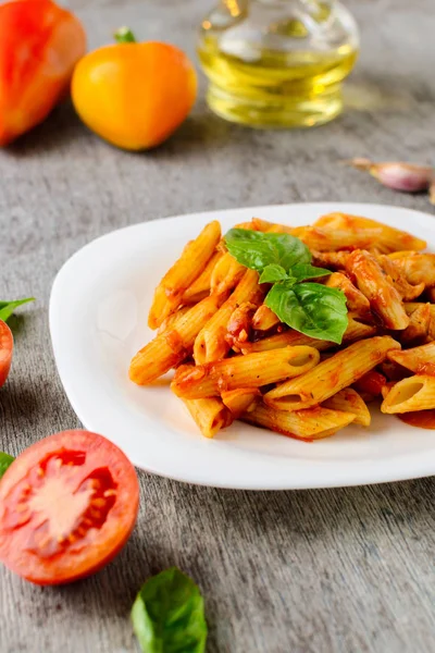 domates sosu ve fesleğen ahşap arka plan ile makarna