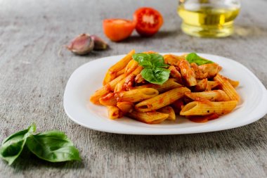 domates sosu ve fesleğen ahşap arka plan ile makarna