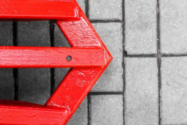 yolda kırmızı ok. Kırmızı işaretçi, gri asfalt üzerinde bir işaretçi şeklinde demir inşaat