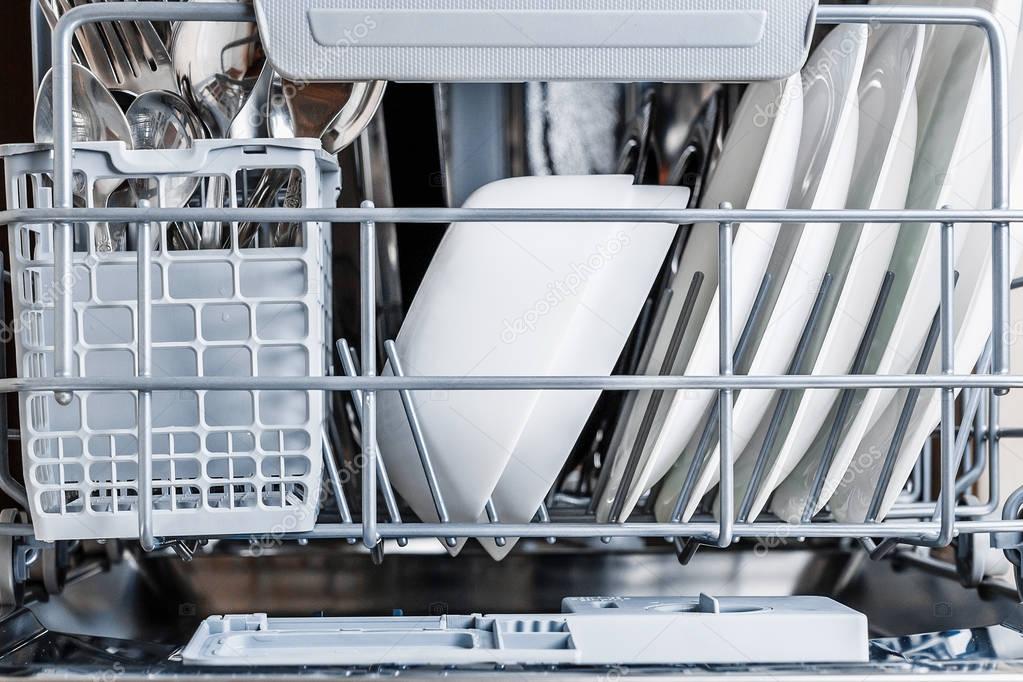 Open dishwasher with clean glass and dishes.