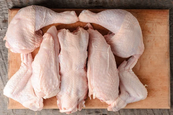 Carcassa di pollo, tagliata a pezzi sul tagliere — Foto Stock