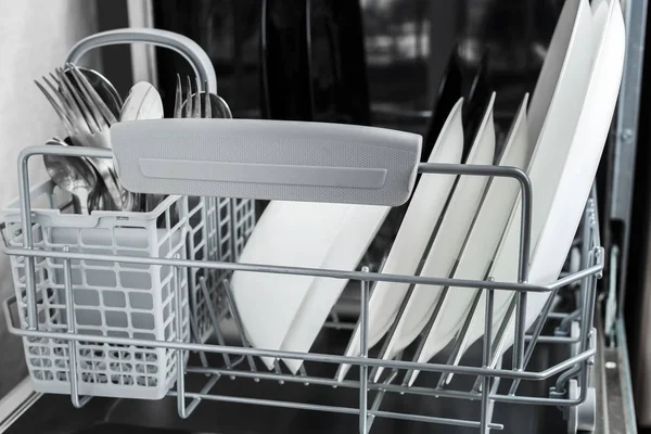 Pratos limpos e outros pratos após a lavagem na máquina de lavar louça — Fotografia de Stock