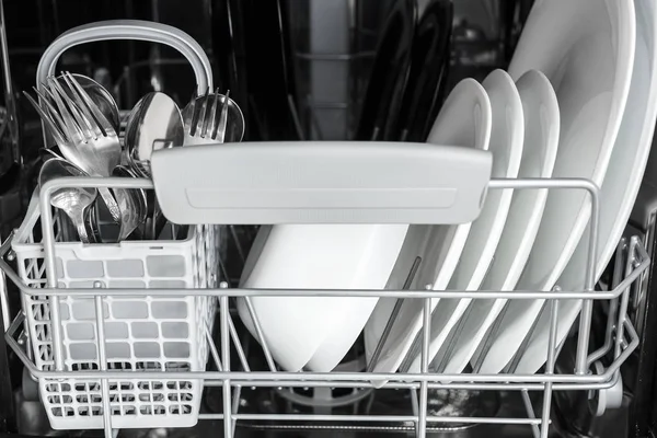 Відкрита посудомийна машина з чистим посудом всередині — стокове фото