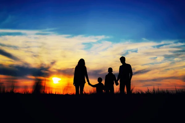  Baba, anne ve çocuk günbatımı bir arka plan üzerinde ellerini tutun.