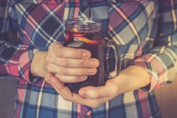 Egy fiatal nő, egy póló tart egy bögre házi készítésű forralt győzelem — Stock Fotó