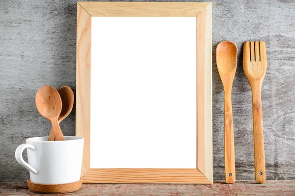Ahşap bir masa üzerinde boş ahşap çerçeve ve mutfak gereçleri — Stok fotoğraf