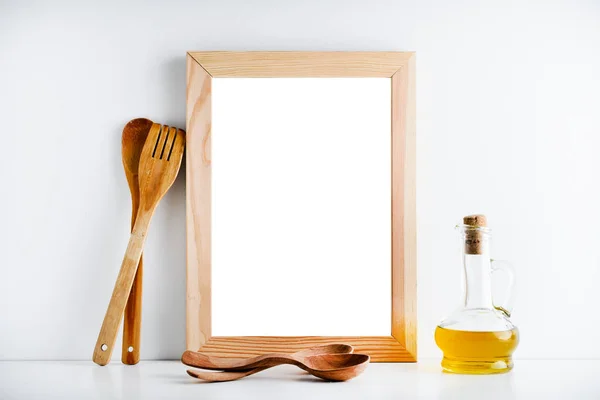 Un marco de madera vacío y accesorios de cocina en un fondo blanco — Foto de Stock