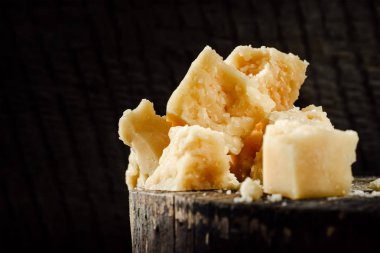 koyu ahşap arka plan üzerine Parmesan peynir parçalarını
