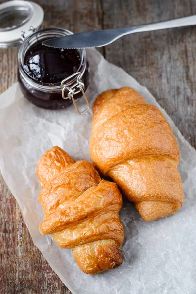 Two appetizing fresh croissants and jam