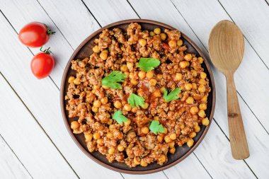 Domuz eti ve bir beyaz tahta masada bir tabakta Nohut ile Şili ana sayfa görünümü.