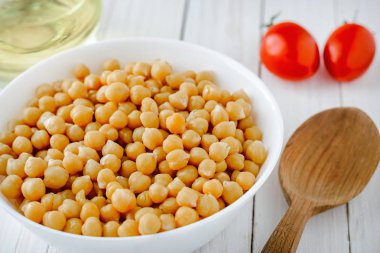 Bir tabak, domates ve zeytinyağı ahşap bir masa üzerinde pişmiş nohut