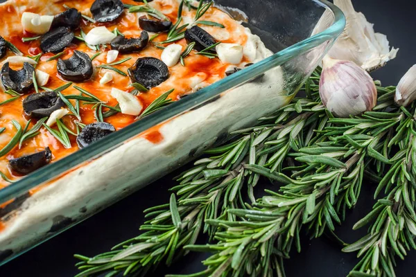 Итальянская вегетарианская фокачча из домашнего хлеба с оливками, розмарином и чесноком — стоковое фото