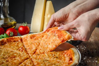 kadının elleri alır bir parça pizza