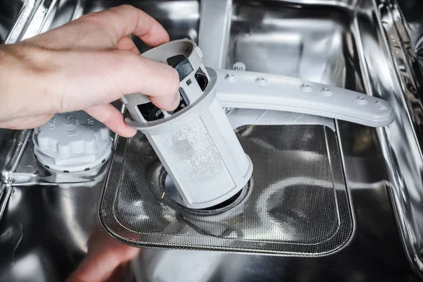 Man cleans the filter in the dishwasher. — Stock Photo, Image