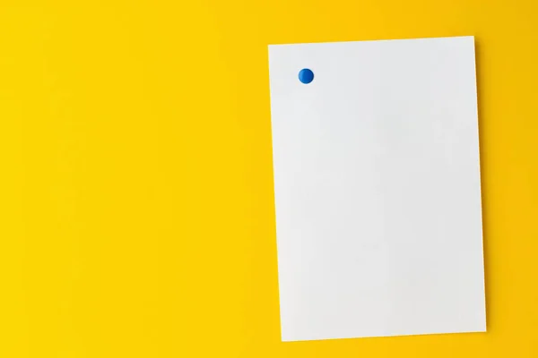 Pusty arkusz biały jest przypięty na żółtym tle — Zdjęcie stockowe