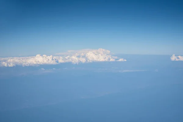 Blue cloudy sky, view from the airplane window. Aerial view of c