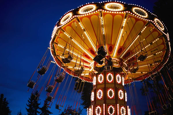 Carrossel Merry-go-round no parque de diversões em uma cidade noturna — Fotografia de Stock