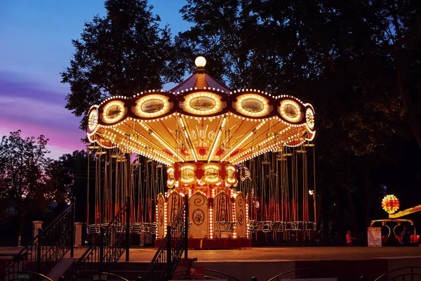 Carousel Merry πηγαίνετε γύρω στο πάρκο διασκέδασης στην πόλη το βράδυ — Φωτογραφία Αρχείου