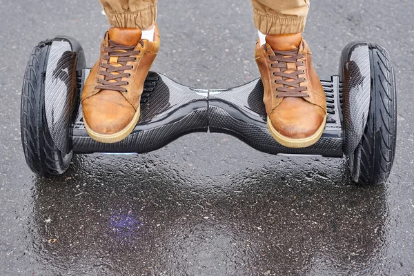 Close up of man using hoverboard on asphalt road. Feet on electr — Stock Photo, Image