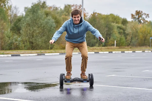 Muž na hoverboardu a pomocí smartphone venkovní — Stock fotografie