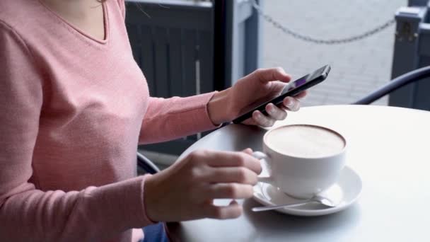 Vrouw Met Behulp Van Smartphone Het Drinken Van Koffie Aan — Stockvideo